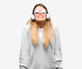 Young woman listen to music with headphone thinking and looking up expressing doubt and wonder