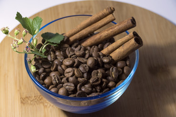 Coffee beans with cinnamon in a transparent plate