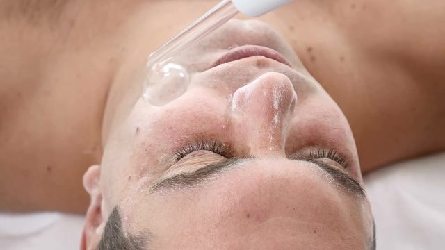 Darsonvalization. Man having darsonval therapy. Facial skin care in beauty saloon. electric darsonval massage procedure
