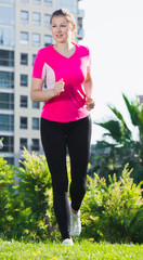 Adult female in pink T-shirt is running