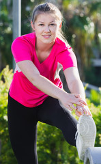 Female in pink T-shirt is doing workout
