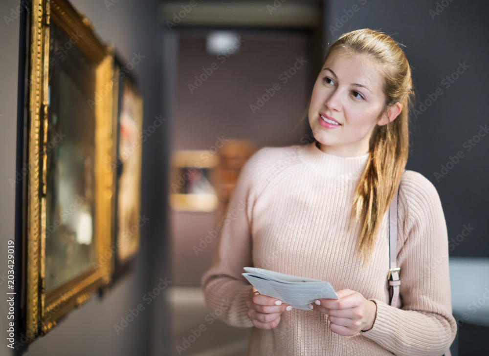 Poster Woman with guide looking at pictures in museum