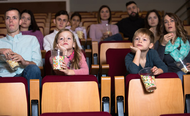 Emotional audience eating popcorn and enjoy watching movie