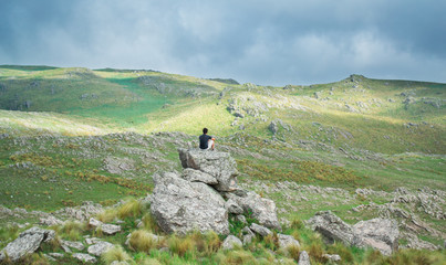  Young man sitting looking at the mountain