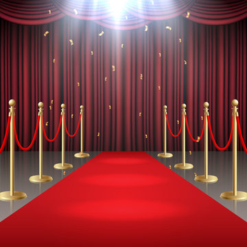 Red carpet and curtain and  barrier rope in glow of spotlights