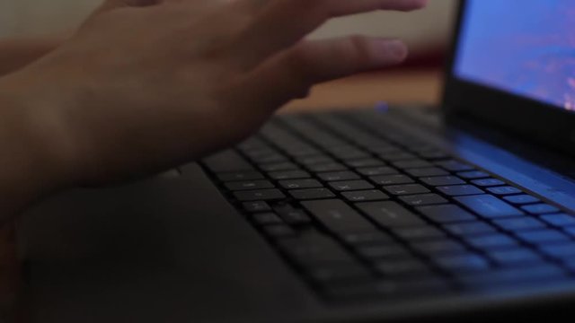 man working on laptop at night. Print text on keyboard.