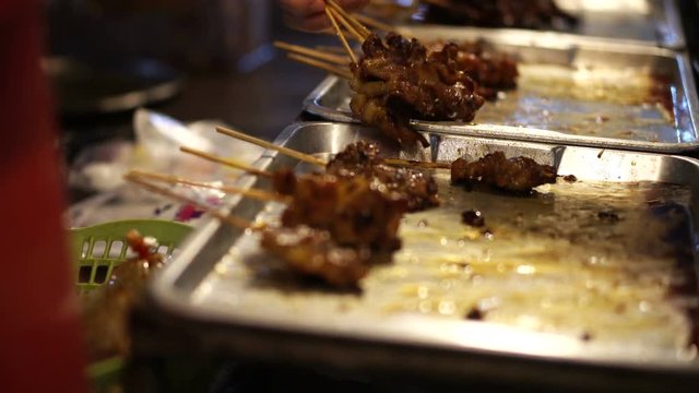 Hand Picking Moo Ping, Thai pork skewer bbq at night 4k