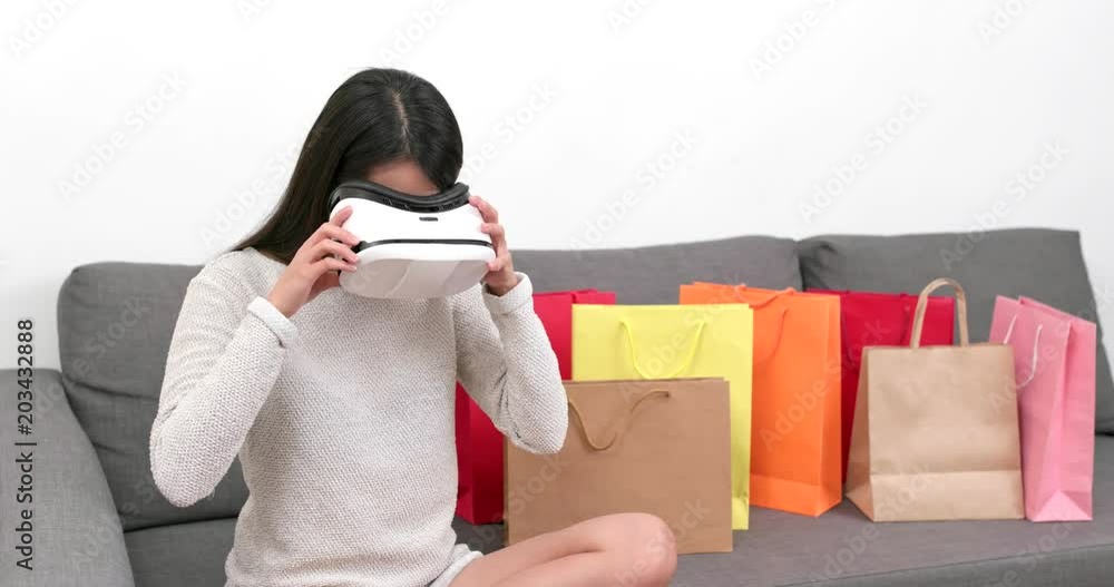 Wall mural Woman using virtual reality device for shopping experience at home