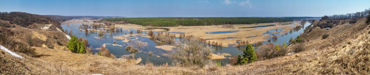 Fototapeta na wymiar Spring landscape, panorama - spring flood in river valley of the Siverskyi (Seversky) Donets, the winding river over the meadows between hills and forests, border region of Ukraine near to Russia