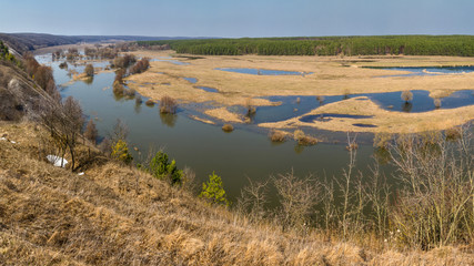 Spring landscape, panorama - spring flood in river valley of the Siverskyi (Seversky) Donets, the winding river over the meadows between hills and forests, border region of Ukraine near to Russia