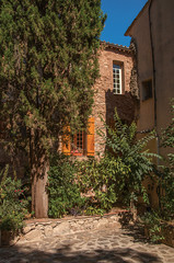 Fototapeta na wymiar View of stone houses in a narrow alley, at the gorgeous medieval hamlet of Les Arcs-sur-Argens. Located in the Provence region, Var department, southeastern France