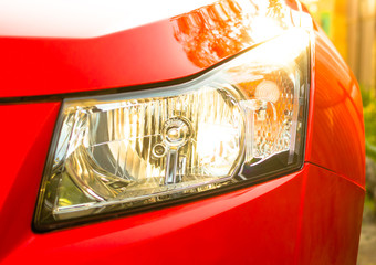 front car headlight, red sports car, sunlight falls on the hood