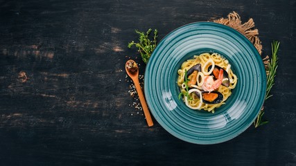 Seafood Pasta. On a wooden background. Italian cuisine. Top view. Copy space.