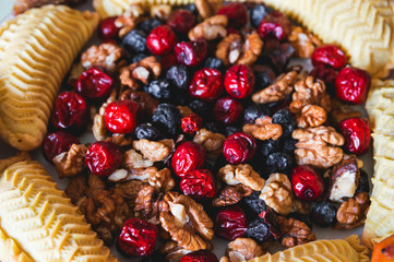 Sweets and desserts for the Novruz holiday on plate - shekerbura, baklava, walnuts and dried fruits