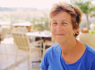 close up portrait of senior woman sitting in outdoor summer cafe