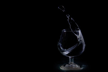 Splash of water in a glass on a black background