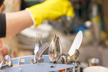 Woman's hands in the gloves wash plate horizontal closeup. selected focus