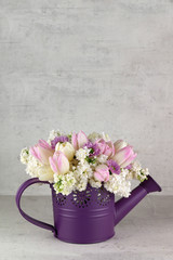 Gießkanne mit Blumenstrauß