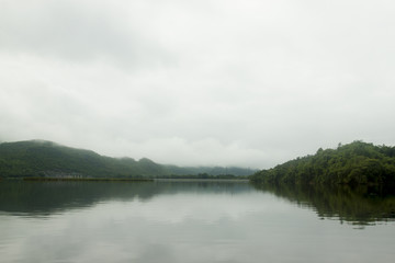 Obraz premium Landscape of Mountain on Reservoir Tha Thung Na under cloudy on morning at Kanchanaburi Province of Thailand.