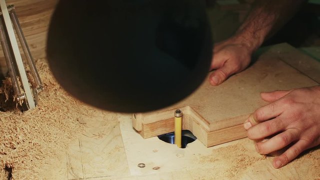Manufacturing of wooden products for kitchen, carpenter working on copy shaper machine