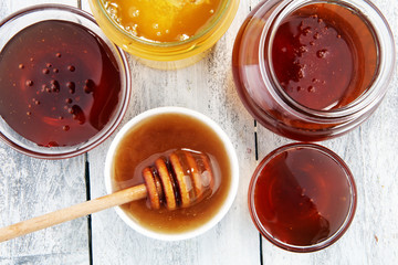 Pouring aromatic honey into jar, closeup