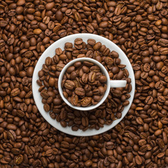 The coffee cup and saucer are filled with coffee grains and resemble the computer's power button