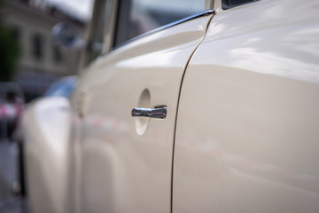 A close up look at an old classic white car. Retro automobile exterior scene. Old vehicle.