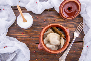 Meat dumplings, are served with sour cream and pepper
