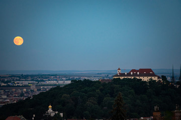 Evening view of Supermoon rising over old town. Night shot of Brno cityscape, Czech Republic.