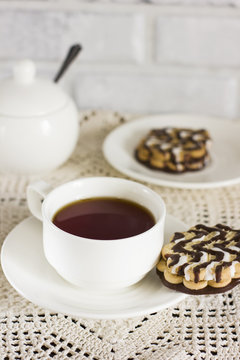 Chocolate biscuits on white plate and Cup of tea on the table