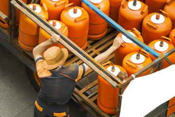 delivery worker with gas butane bottles lgp gpl - obrazy, fototapety, plakaty