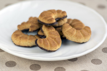 Biscuits rolls on white plate, tasty chocolate sweets for tea break