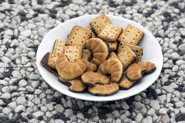 Biscuits rolls on white plate, tasty chocolate sweets for tea break
