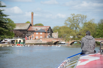 Retired lonely man sat on bow of boat wearing grey jumper with gray hair contemplating the...