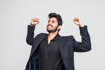 Portrait of excited Asian Indian businessman celebrating success over white background