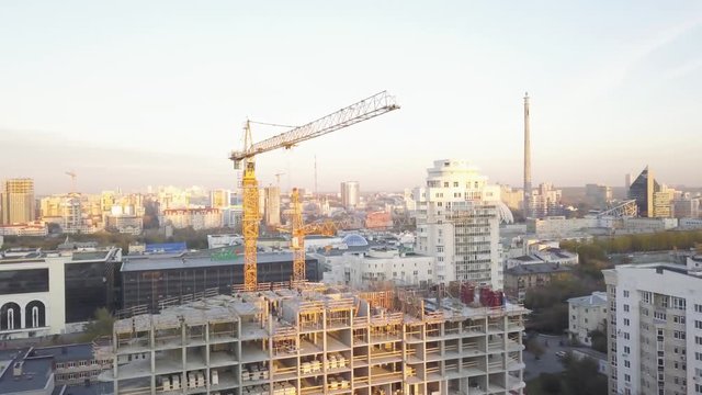 Construction site with cranes. Video. Construction workers are building. Aerial view. Top view of the construction site in the city. Construction in the city with a crane manipulator