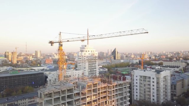 Construction site with cranes. Video. Construction workers are building. Aerial view. Top view of the construction site in the city. Construction in the city with a crane manipulator