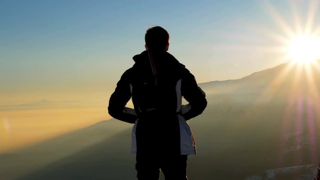 Bielmonte, Italy, January 29, 2018 - Sunset with young man watching the sun descend in snowy mountains,  Mount Mucrone to Matterhorn , Alps, Italy