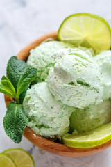 Mojito ice cream with lime slices and mint sprigs.
