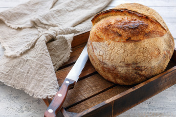 Loaf of wheat artisan bread in a wooden box.