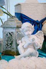 White sculpture of an angel against the background of old lights