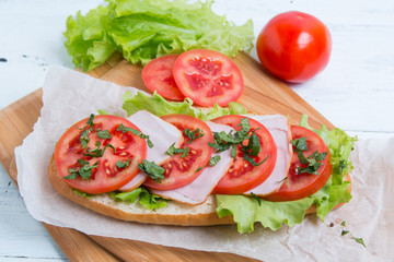 baguette sandwich with ham, tomatoes and lettuce