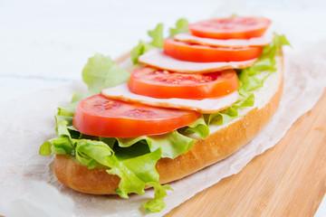 baguette sandwich with ham, tomatoes and lettuce