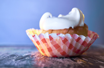 Cupcake with cream on a pastel background on a wooden table