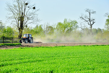 Traktor i maszyna rolnicza podczas pracy na polu. - obrazy, fototapety, plakaty