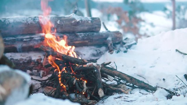 Campfire in the winter forest in normal speed, travel survival concept, winter fun expedition, hiking and active lifestyle