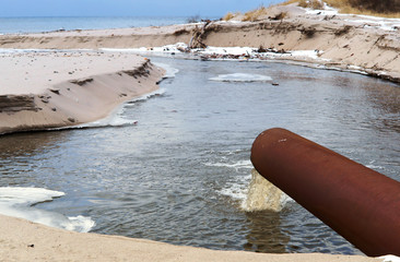 Sewer pipe into the sea. The dirty drain waste water. Environmental pollution.