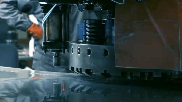 Worker operates with Coordinate Punching Press CNC machine 