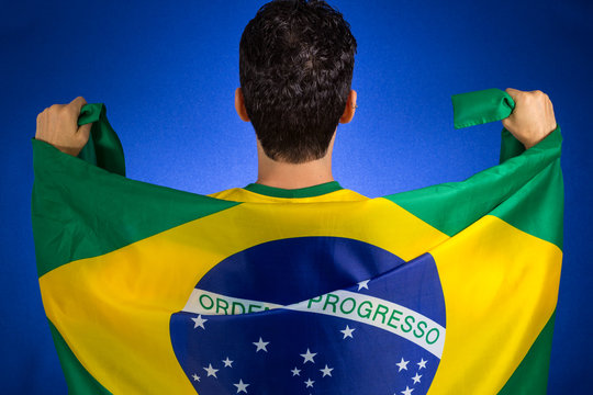 Brazilian soccer football player holding Brazil flag.