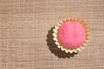 Bicho de pe is a strawberry flovoured brazilian candy. Children birthday party sweet. Flat lay design of candy ball over wood.